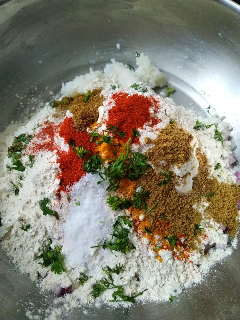 add flour and spices to bhatache thalipeeth